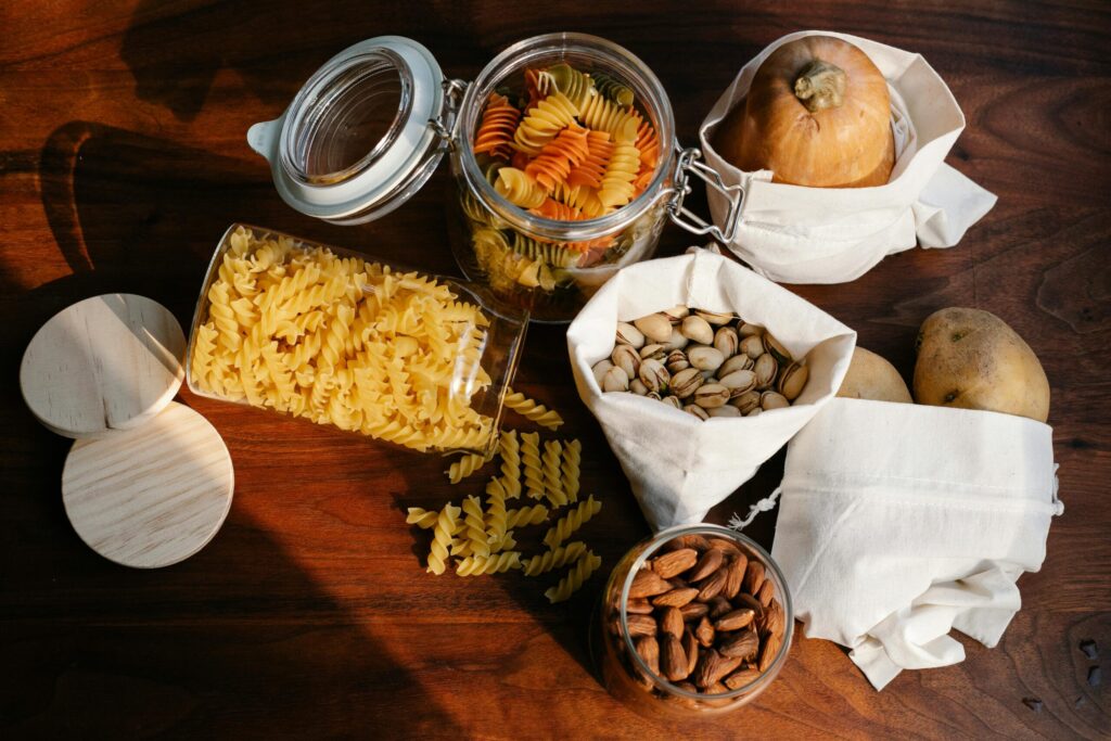 pexels-photo-7262798-7262798 Top view jars of raw pasta placed on wooden table near ECO friendly sacks with pistachios and almonds near pumpkin and potatoes