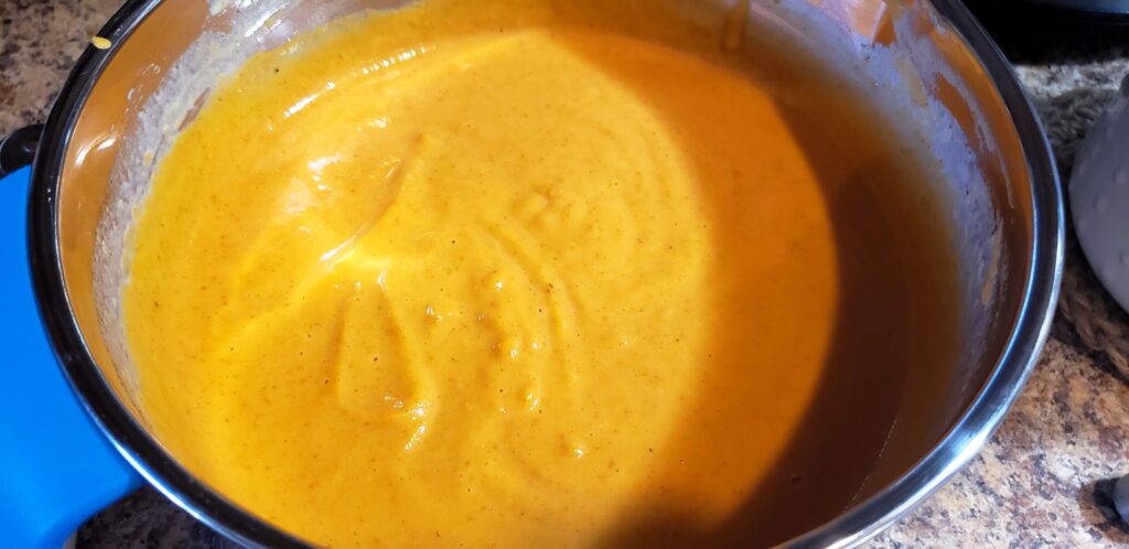Pumpkin pie filling mixture whisked smooth in a mixing bowl, ready to pour over crust