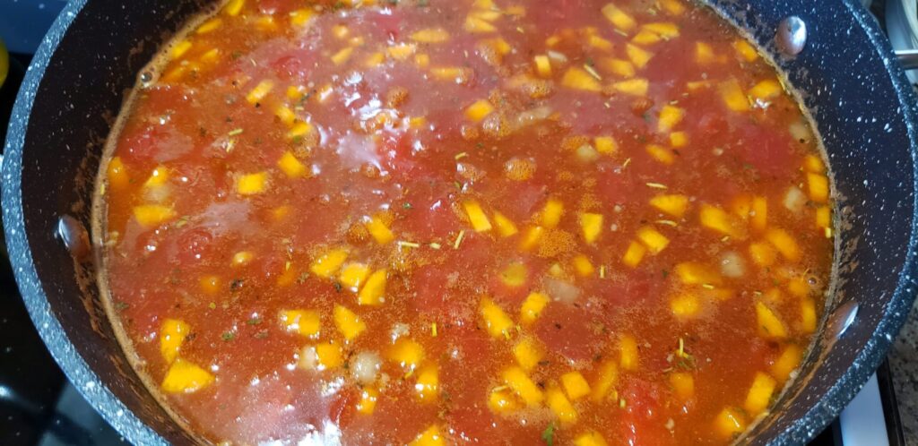 Hearty hamburger soup simmering in a pot with ground beef, potatoes, and tomato broth